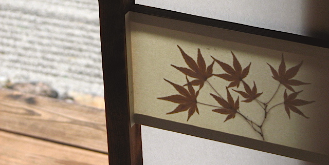 A maple leaf pressed in between two sheets of washi paper in a Japanese shoji screen in Kyoto, Japan.