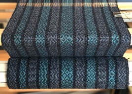 A blue and teal scarf still on the loom