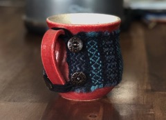 An offcut of blue and teal scarf crafted into a cosy mug warmer