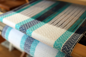 A blue and teal set of placemats still on the loom
